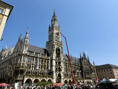 Das Rathaus am Münchner Marienplatz mit einer langen Hebebühne davor, um etwas an der Uhr zu machen