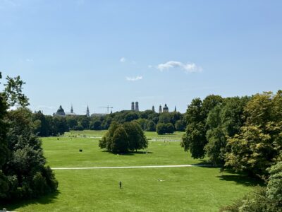 Blick über den Englischen Garten vom Monopteros aus, im Hintergrund diverse Kirchtürme und ein Kran